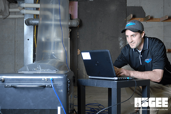 A man sitting at a desk, focused on his laptop computer.
