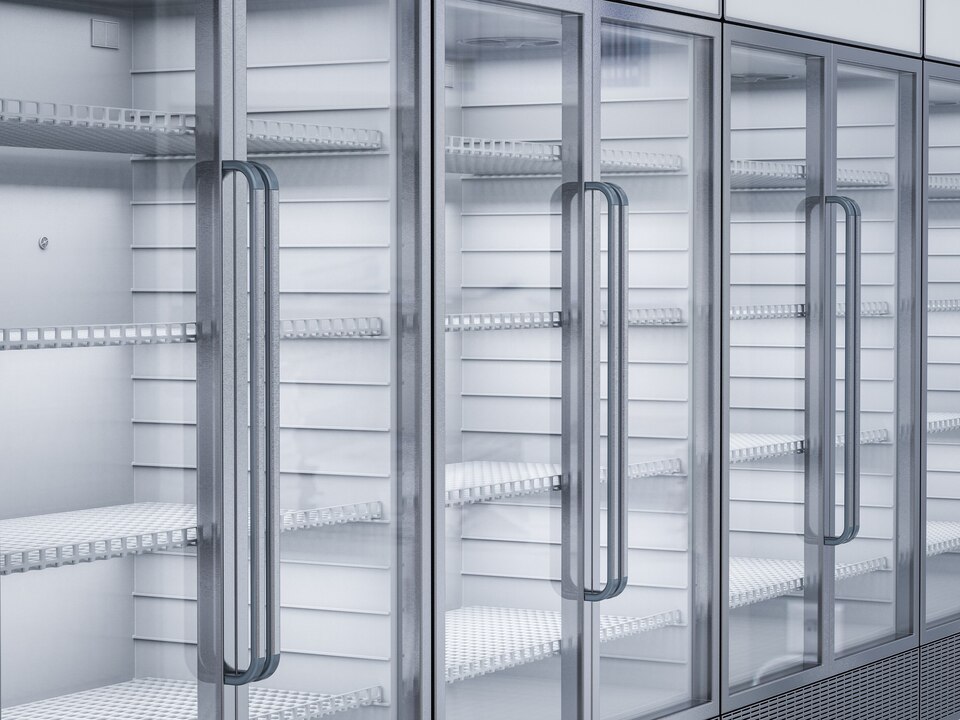 A large freezer featuring glass doors and multiple shelves, showcasing various frozen food items inside.